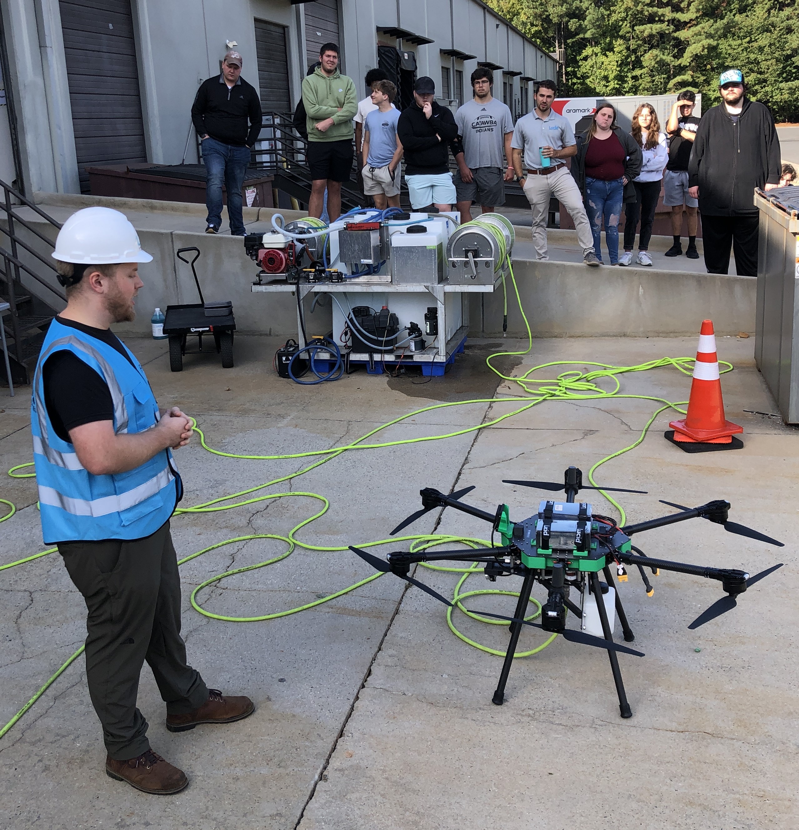 Andrew Ashur demonstrates his cleaning drone to a group of Catawba students
