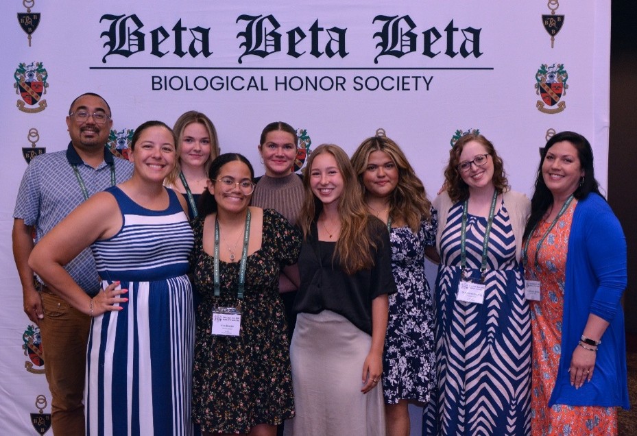 Catawba College students and advisors pose with the Tri Beta sign