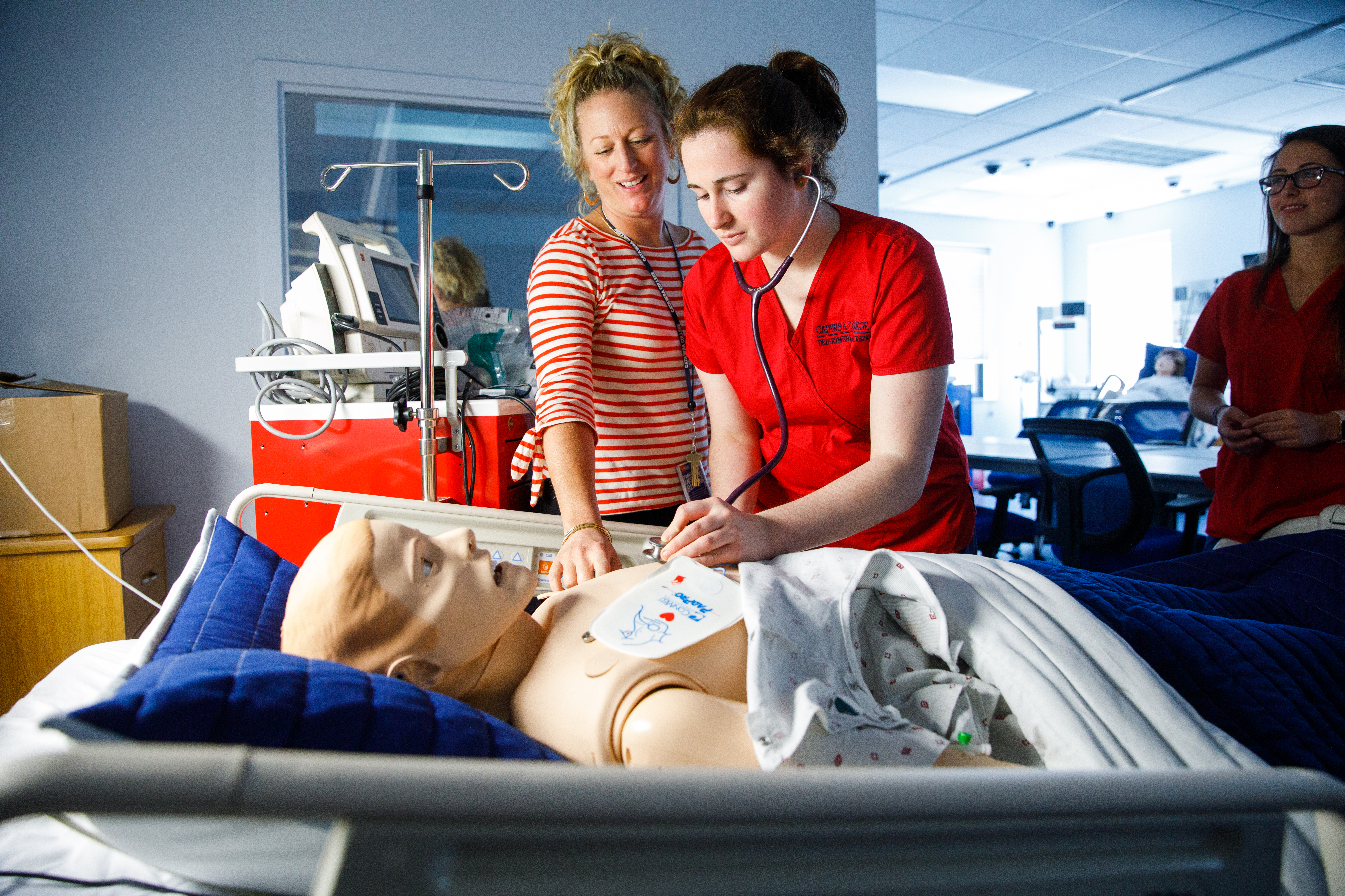 Nursing Student and Faculty with sim lab manikin
