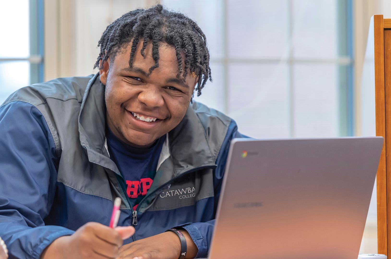 Catawba College student smiling at computer