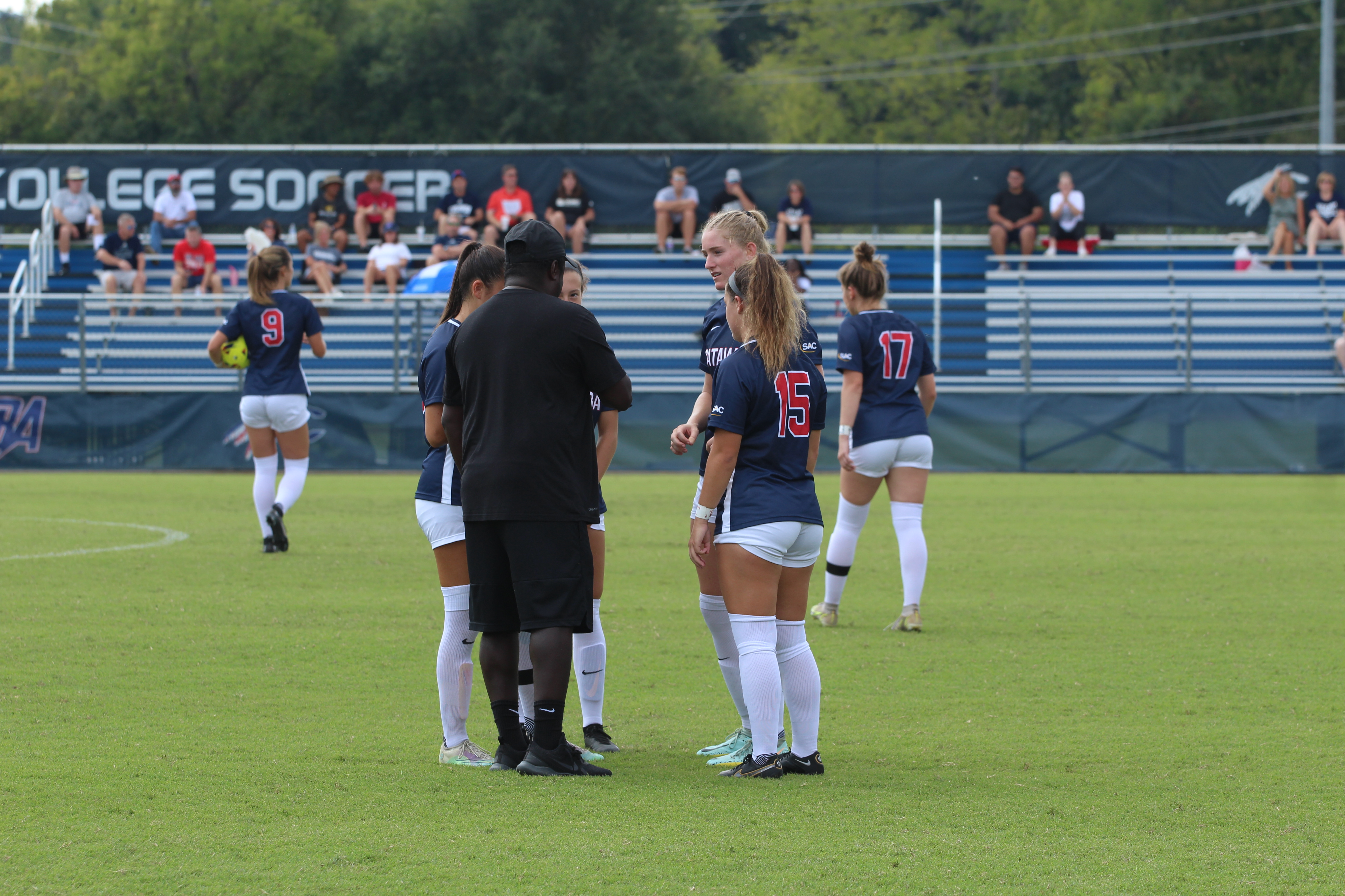 Coach Nick Brown with Women's Soccer Team on field