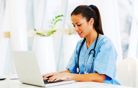 RN to BSN Nursing Student on laptop in scrubs