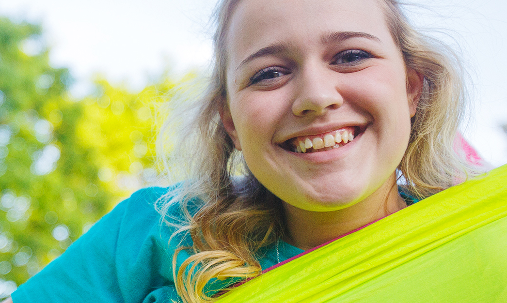 Student in a hammock smiling