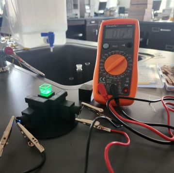 Fluorometer connected to multimeter with a glowing cuvette