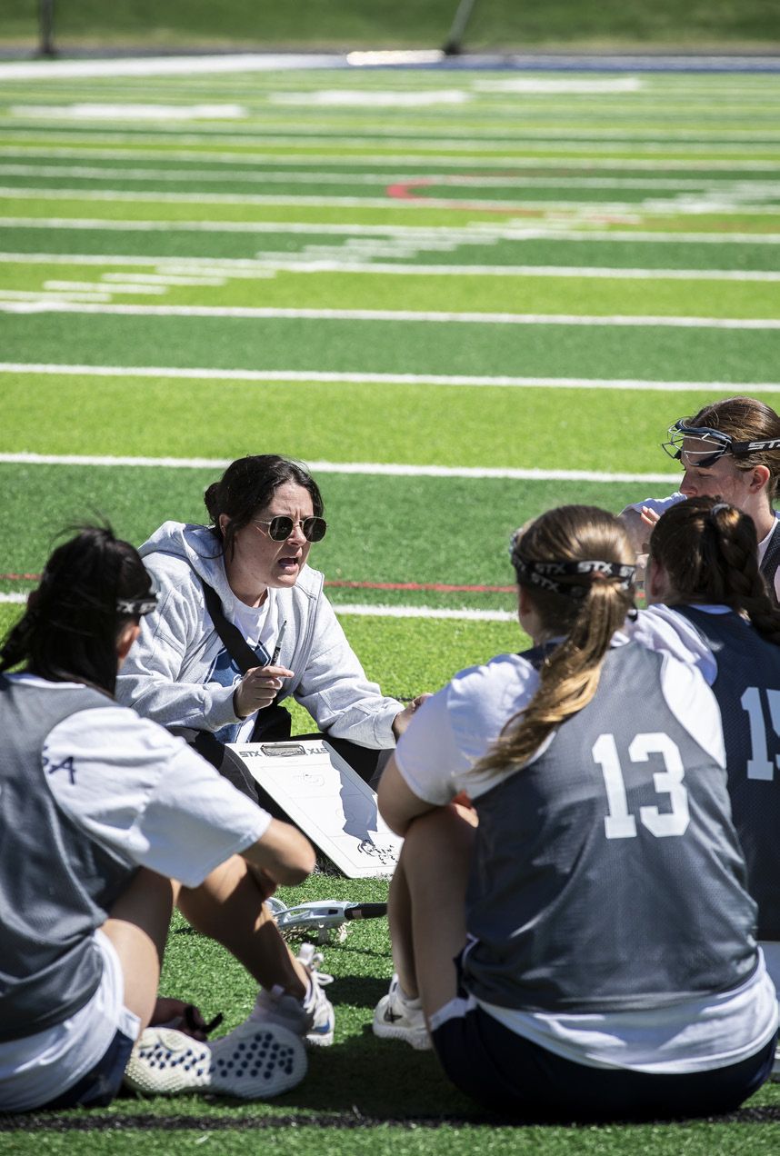 Women's athletic team on the field with coach